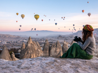 You can offer (or take) learning, travel tours at Dash Class. Lady taking pictures of hot air ballons rising over a canyon.