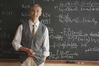 You can be a teacher (or be taught by one) at Dash Class. A teacher smiling in front of a chalkboard with hundreds of equations artfully written behind him.